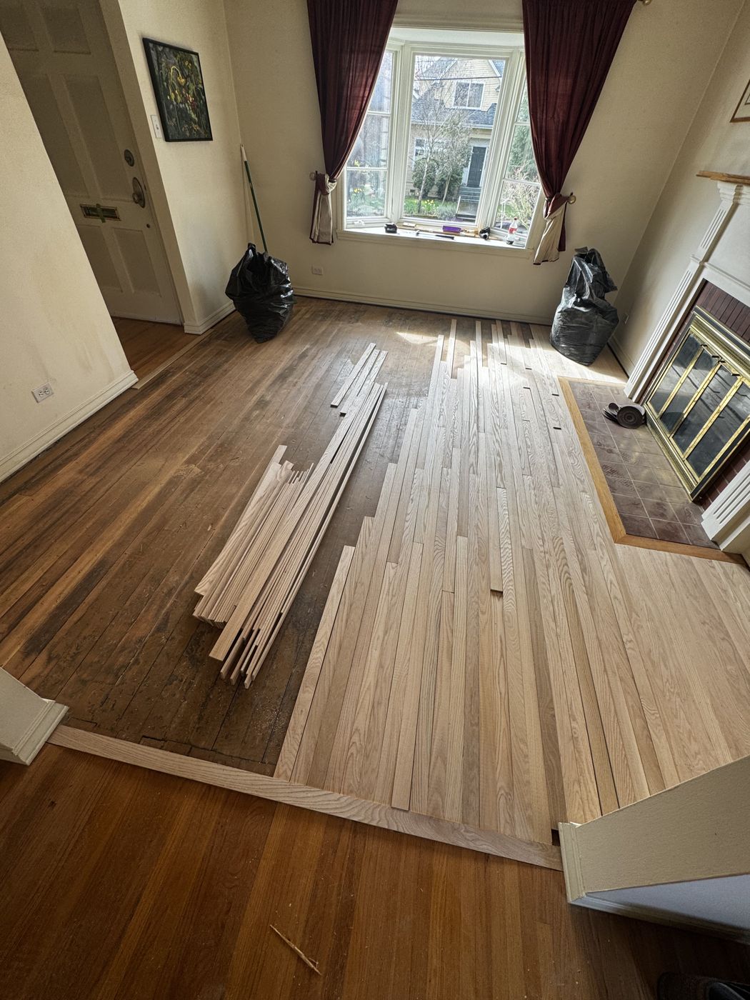 New oak boards woven into an original floor during a Ballard, Seattle restoration