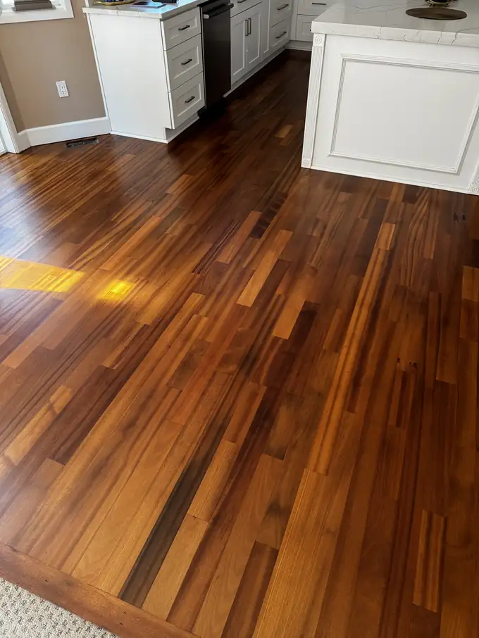 Refinished tatajuba floor with gold and reddish-brown boards beside a kitchen island