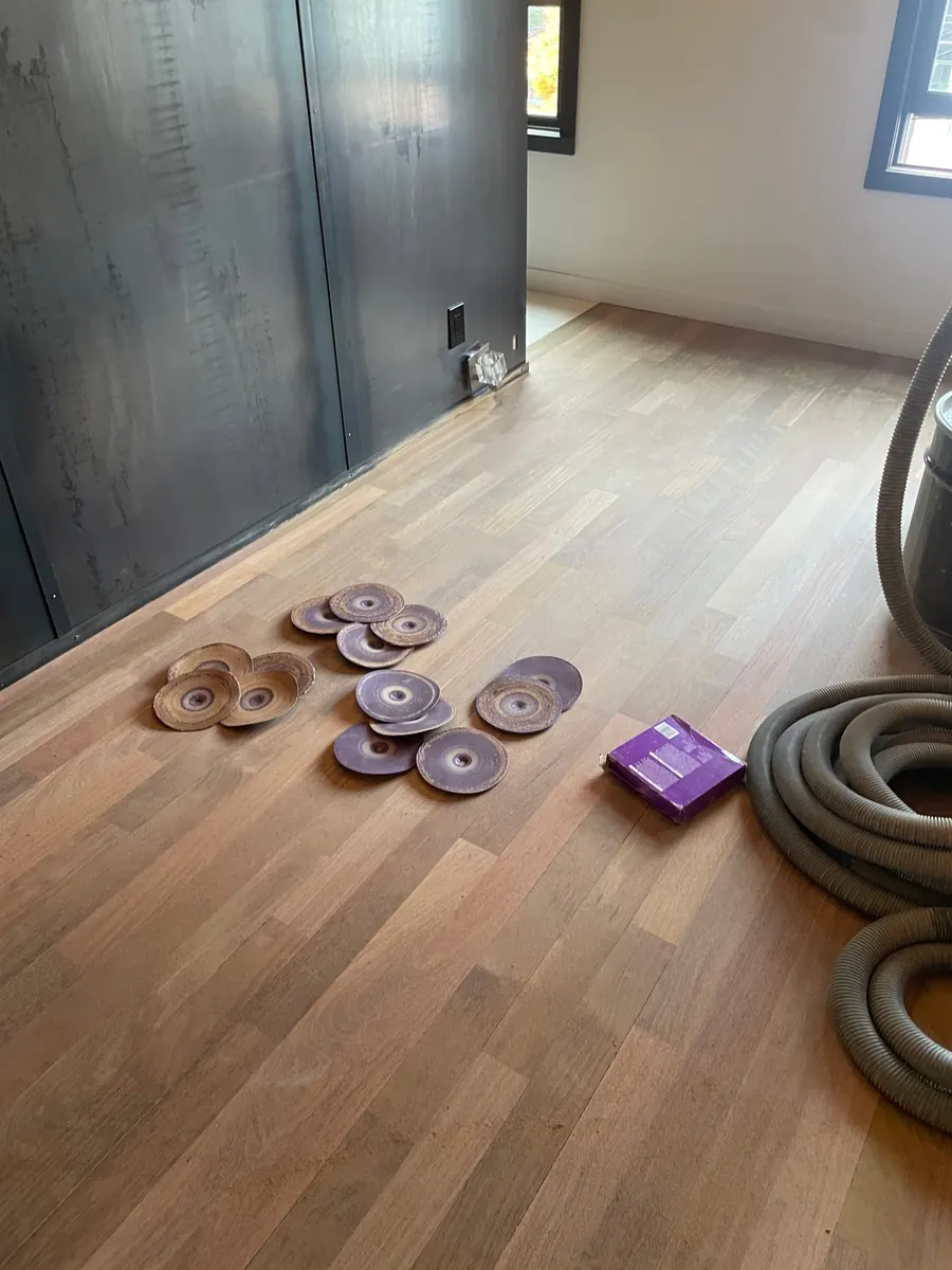 Ipe Floor Refinishing in Capitol Hill, Seattle 6 Ipe floor sanded to bare wood with used sanding discs and dust-collection hose